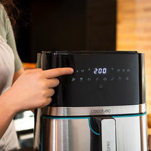 Cargar imagen en el visor de la galería, Primer plano de una mano interactuando con la pantalla digital de la freidora de aire Cecofry Full Inox 5500 Pro, mostrando ajustes de temperatura e iconos de cocción.
